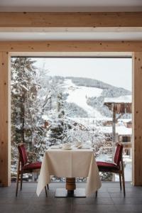 圣维吉利奥Hotel Chalet Corso的享有雪覆盖山脉景致的客房内的桌子