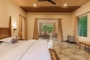 坎哈Jungle King Resort的一间卧室设有一张大床和一个大窗户