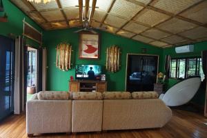 北碧The Parrot Inn Kanchanaburi的带沙发和绿色墙壁的客厅
