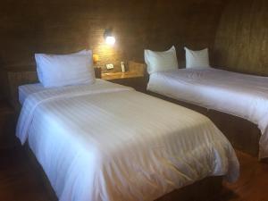 Lang SuanBan Tawansongfa的配有白色床单的酒店客房内的两张床