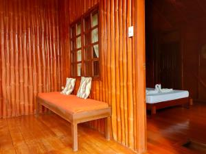 锡基霍尔Winyanz Tambayan Tourist Inn的木制客房设有长凳和一张床