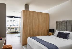 悉尼Punthill Parramatta的一间卧室配有一张大床和木制床头板