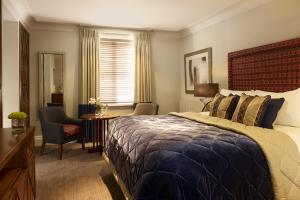 埃文河畔斯特拉特福斯特拉特福阿尔登酒店 - 伊登连锁酒店的一间卧室配有一张大床和一张桌子及椅子