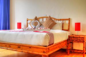 纳纽基Peaks Hotel Nanyuki的一间卧室配有一张木床和两盏红灯