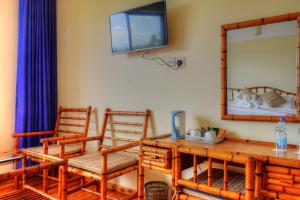 纳纽基Peaks Hotel Nanyuki的一间配备有桌子和两把椅子及一台电视的房间