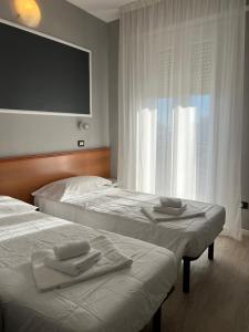 里米尼斯特拉意大利亚酒店的酒店客房设有两张床和一台平面电视。