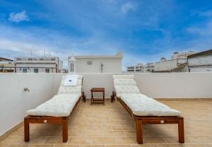 夫塞塔Tia Anica House II - apartment with terrace in central Fuseta beach village的屋顶上两把白色椅子