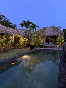 金巴兰La Reserva Villas Bali的夜间别墅前的游泳池