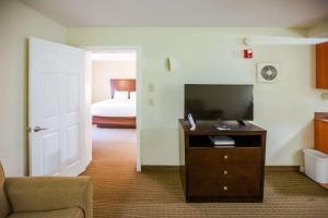 诺克斯维尔MainStay Suites Knoxville North I-75的带电视的客厅和卧室