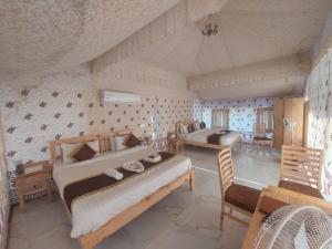 乌代浦Hill View Resort by Rudrakshi的一间卧室配有两张床和一张桌子及椅子