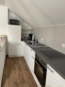 巴特基辛根Ferienwohnung Ela的厨房配有白色橱柜和炉灶烤箱。