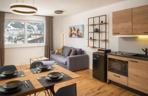 巴德加斯坦Auhof - Apartments Bad Gastein的厨房以及带桌子和沙发的客厅。
