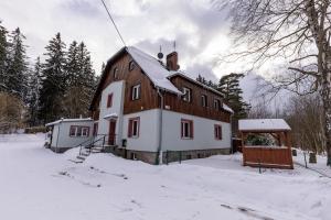 斯克拉斯卡波伦巴Apartament Sarenka的一座大木屋,地面上积雪