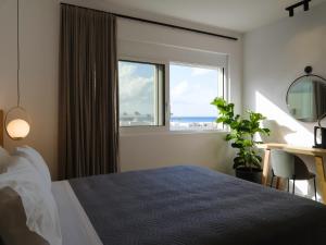 阿德里安诺斯坎波斯Sea La Vie的一间卧室配有一张床、一张书桌和一个窗户。