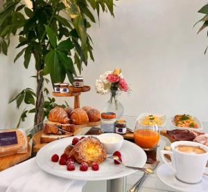 卡斯特拉玛雷帝斯达比亚Experience Boutique Hotel - Villa Cimmino的一张桌子,上面放着一盘食物、咖啡和糕点