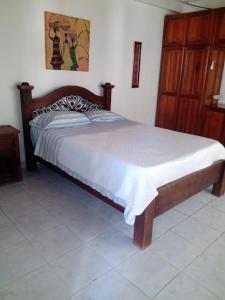 莱蒂西亚Villas de León的一间卧室配有一张木架大床