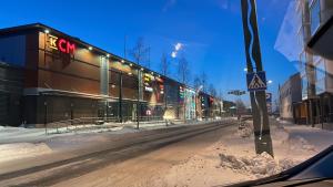 托尔尼奥Style 1BR with sauna,Tornio city的一条雪 ⁇ 的街道,旁边是一座cgi建筑