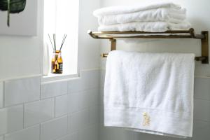 高雄苓居－包栋民宿的浴室提供毛巾架上的白色毛巾