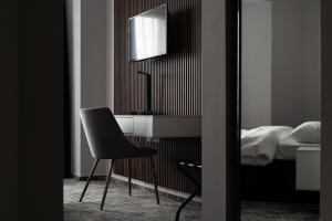 克卢日-纳波卡Hotel Cristal的一间卧室配有一张桌子和一张椅子,位于床边