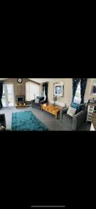 拉尔Luxury Caravan - WI-FI and SMART TV newly installed的带沙发和蓝色地毯的客厅