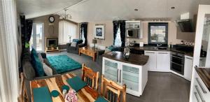 拉尔Luxury Caravan - WI-FI and SMART TV newly installed的厨房以及带沙发和桌子的客厅。