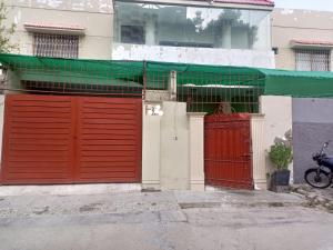 卡拉奇Karachi Guest House & Couple Hotel的街上有两扇红色车库门的建筑