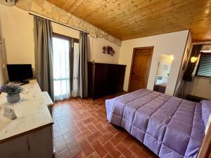 蒙特梅拉诺Agriturismo Poggio del Drago的一间卧室配有一张紫色的床和一张书桌
