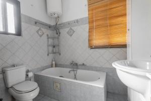 拉里萨Delight apartment LA的浴室配有卫生间、浴缸和水槽。