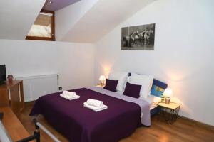 布雷兹诺Apartmán Ivka的一间卧室配有一张紫色床和两条毛巾
