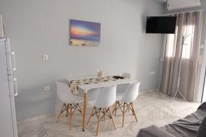 科斯镇Bright & Comfy Apartments near the beach的一间设有白色桌子和白色椅子的用餐室