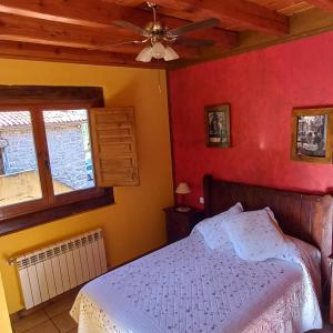 San Roque de Ríomiera旧学校旅馆的一间卧室配有一张床和吊扇
