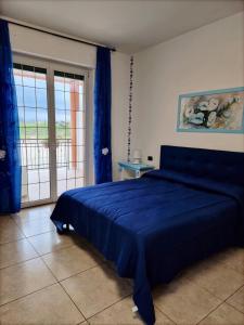 泰尔莫利Pepe rosa的一间卧室设有蓝色的床和滑动玻璃门