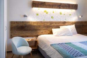 奥斯塔Hirondelle Locanda的一间卧室配有一张带木制床头板和椅子的床。