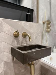 托德莫登Luxury 2 Bedroom Flat in Central Todmorden的浴室设有黑色水槽和金色水龙头