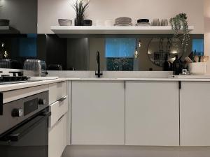 托德莫登Luxury 2 Bedroom Flat in Central Todmorden的厨房配有白色橱柜和水槽