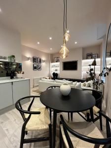 托德莫登Luxury 2 Bedroom Flat in Central Todmorden的厨房以及带桌椅的起居室。