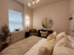 托德莫登Luxury 2 Bedroom Flat in Central Todmorden的一间卧室配有一张床、镜子和一张书桌