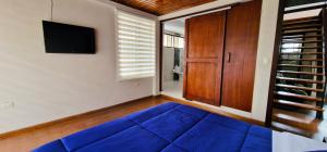 MacasTU CASA EN MACAS的客厅配有蓝色的沙发和电视