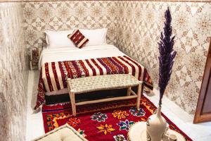 马拉喀什Riad Fz Marrakech的一间小卧室,配有床和地毯