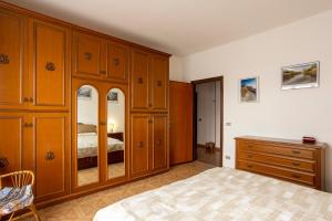 比耶拉Appartamento vista Alpi biellesi的一间卧室配有木制橱柜、一张床和一个梳妆台