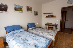 比耶拉Appartamento vista Alpi biellesi的一间卧室设有两张单人床和一张桌子