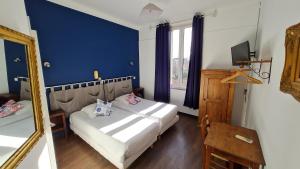 阿尔勒江诗丹顿酒店的一间卧室配有一张带镜子和蓝色墙壁的床