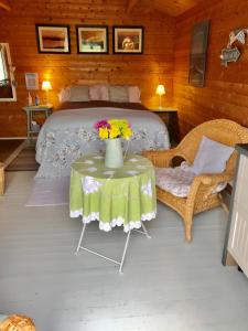 温伯恩大教堂The Log Cabin的一间卧室配有一张床和一张鲜花桌子