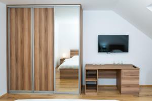 科拉欣Guest House Alte的一间卧室设有滑动玻璃门、书桌和电视。