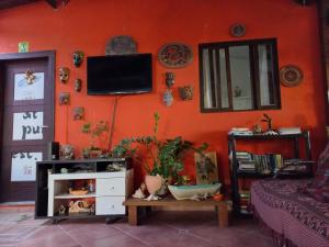 弗洛里亚诺波利斯Floripa Beach House Hostel的客厅设有带电视的橙色墙壁