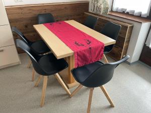 弗拉绍欧博比奇加特公寓的一张桌子,上面有四把椅子和红色的毯子