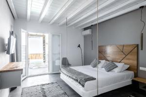 Merchia BeachThe Mykonist Merchia Beach Villas & Suites的一间卧室配有一张带秋千的大床