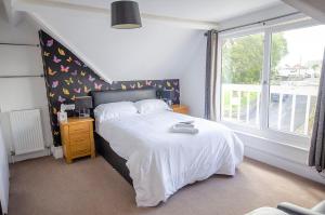 法尔茅斯Headlands - Room Only Accommodation的卧室配有白色的床和窗户。