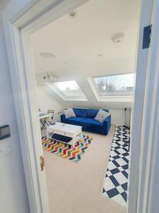 伦敦Jacuzzi Suite的客厅配有蓝色的沙发和桌子