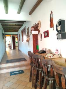 莱瓦镇Hotel El Peregrino De La Villa的配有一张木桌、椅子和小提琴的房间